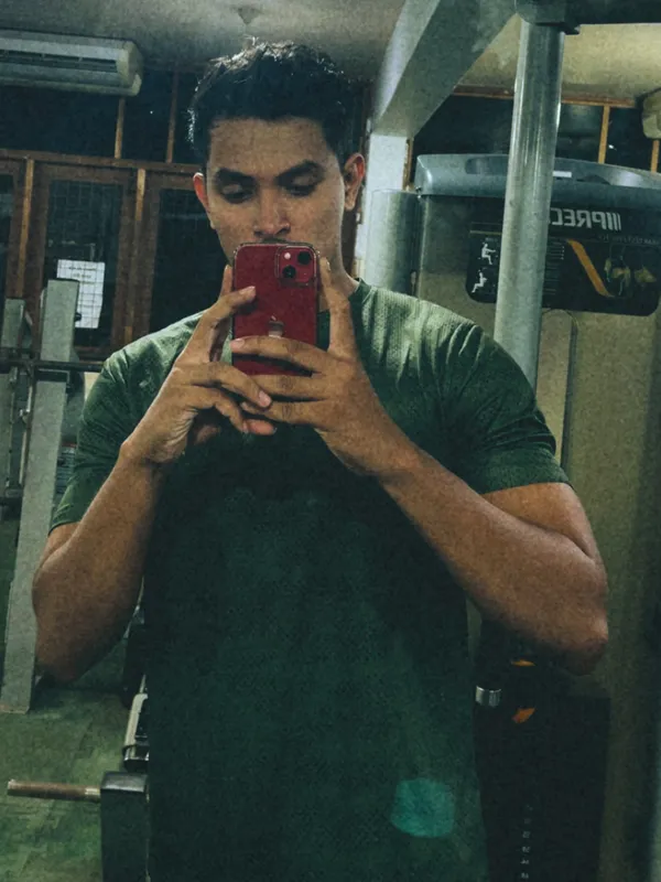 Mirror photo of Shaveen at the gym in a green T-shirt