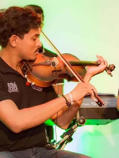 Shaveen playing violin on stage at a university concert