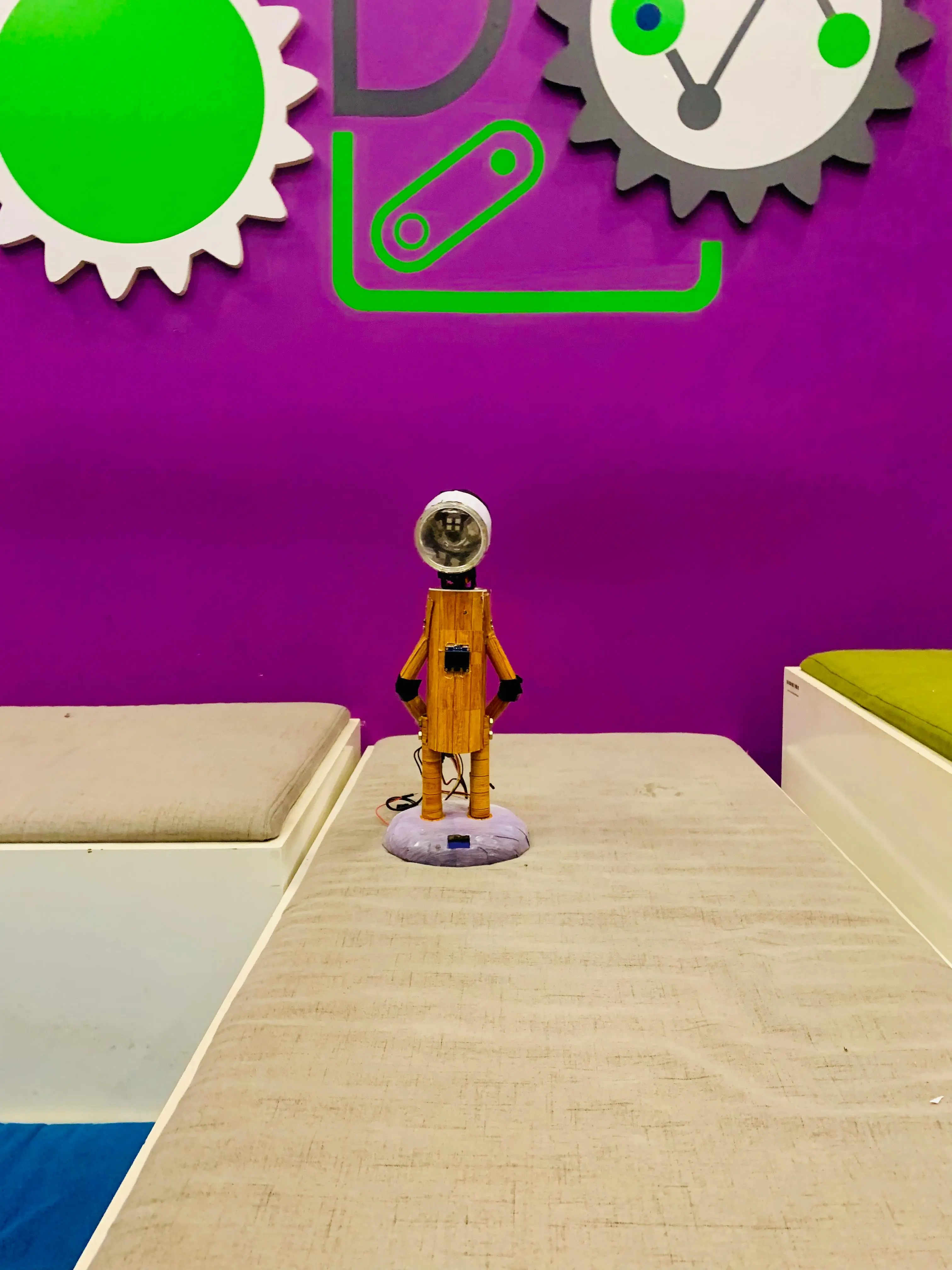 Lumina, a small wooden robotic lamp, standing on a table